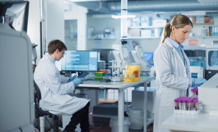 Two scientists in a modern laboratory conduct detailed analysis with samples and computers, ready for water quality testing.