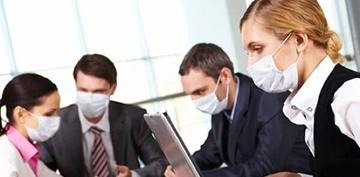 Four masked business professionals reviewing documents in an office, hinting at workplace health concerns.