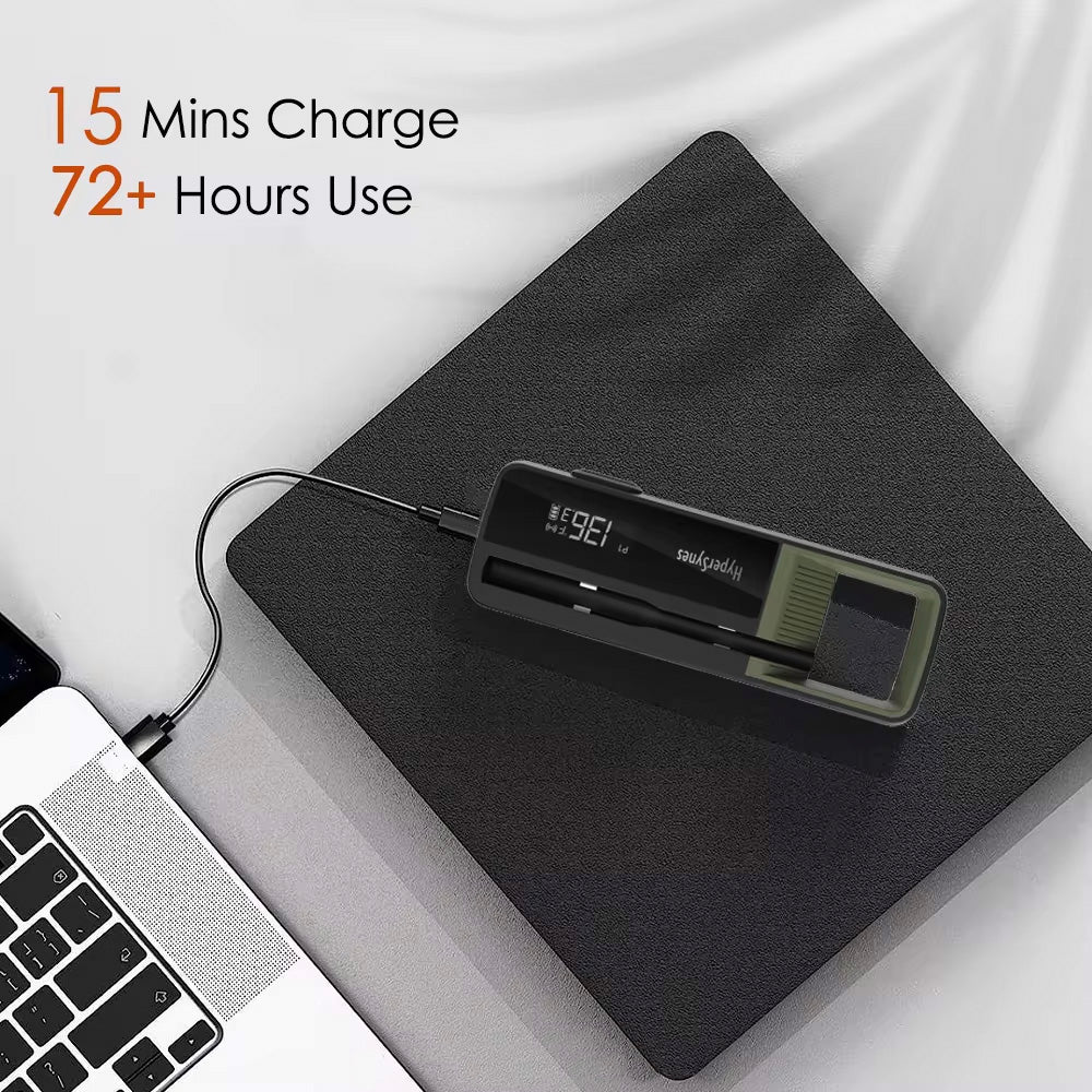 Black smart thermometer by Sper Scientific on a gray surface, charging with a laptop nearby.