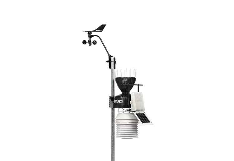 Weather station by Davis Instruments featuring an anemometer and solar radiation shield on a gray pole.
