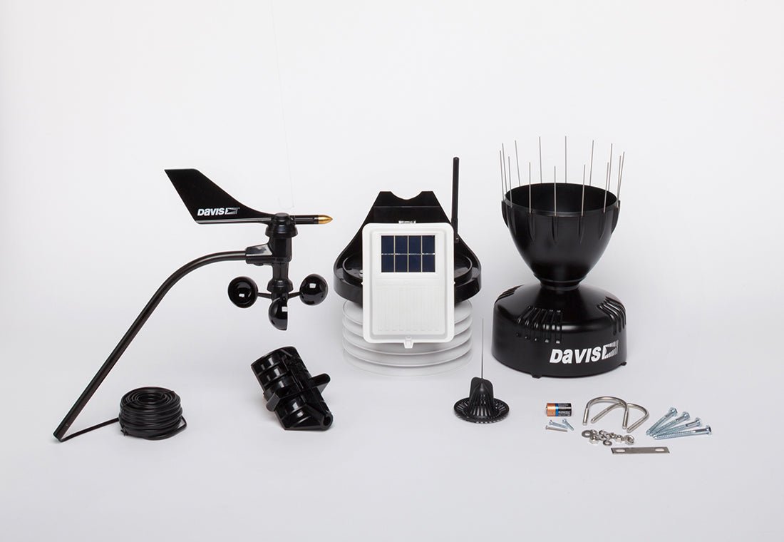 Black wireless weather station by Davis Instruments with an anemometer, console, and rain collector.
