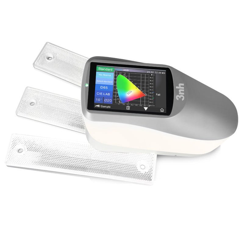 Portable spectrophotometer by 3nh displaying a color chart on its screen, next to three reflective sample panels.
